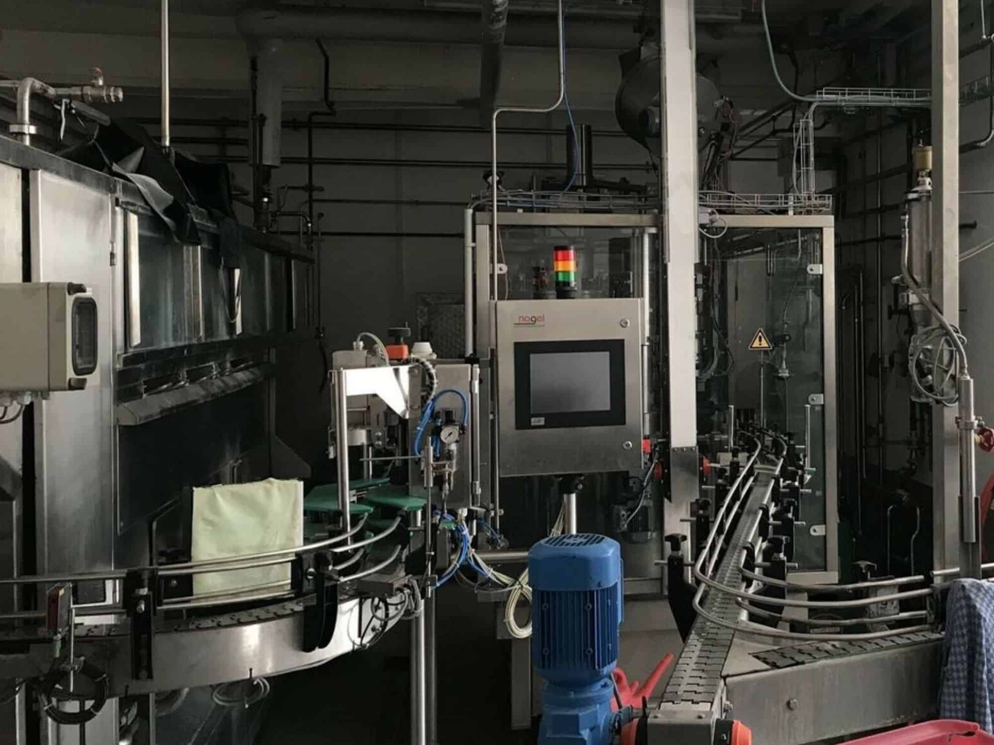 Vista laterale di Nagel, PAC, Juwatec Linea di riempimento bicchieri a rendere per birra e bibite